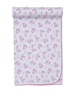 White baby blanket from Kissy Kissy, crafted from ultra-soft Pima cotton and edged with pink stitching, features the Whale Pods design with a charming pink and purple motif, rolled at the top.