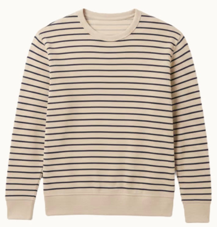 The Faherty Double Knit Crewneck is a beige sweater made from soft Pima cotton with even navy stripes and ribbed cuffs and hem.