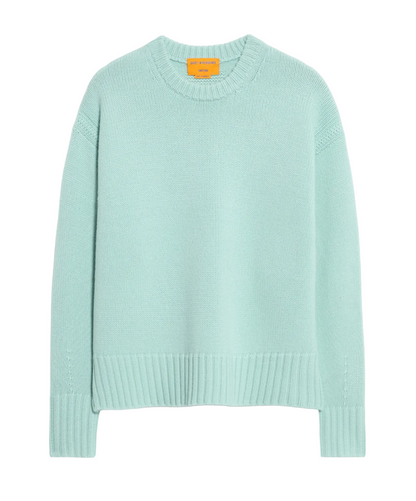 The Guest in Residence Cozy Crew Cashmere Sweater in light blue features long sleeves, a dropped shoulder, and ribbed cuffs, hem, and neckline, shown on a plain white background.