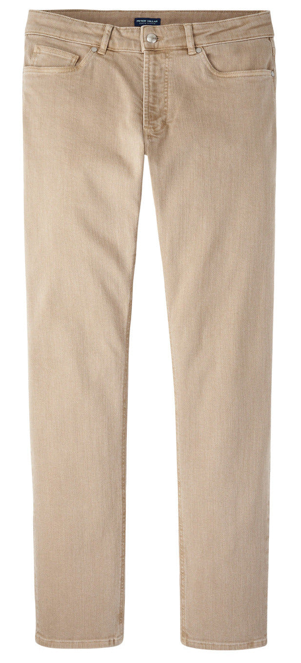 The Peter Millar Fairfield Garment Dyed Denim features beige straight-leg casual pants with button and zip closure, front and back pockets, and cotton stretch fabric, shown laid flat on a white background.