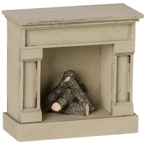 The Maileg Fireplace, Mouse - Off White is a small, wooden model fireplace with a vintage finish and faux logs inside the firebox—perfect for adding charm to your miniature home.