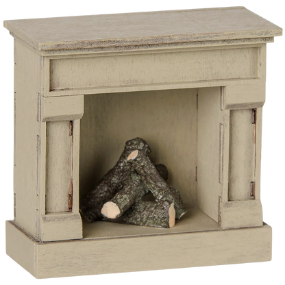 The Maileg Fireplace, Mouse - Off White is a small, wooden model fireplace with a vintage finish and faux logs inside the firebox—perfect for adding charm to your miniature home.