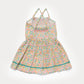 The Girls’ Alisson Dress by Early Sunday is a light pink sleeveless summer dress for children, featuring delicate floral patterns, smocking on the bodice, crisscross straps, and a flared skirt—crafted from soft organic cotton to ensure all-season comfort.