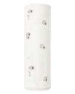A soft, rolled-up Swaddle by Quincy Mae, made from organic brushed jersey for ultimate comfort, featuring a white background with a pattern of small gray sheep, fences, and crescent moons.