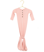 The Lou Lou & Company Baby Girls’ Piper Plush Knit Knotted Gown, in pink with long sleeves, a three-button front, and a knotted tie-bottom design for easy diaper changes, is displayed on a gold hanger against a white background.