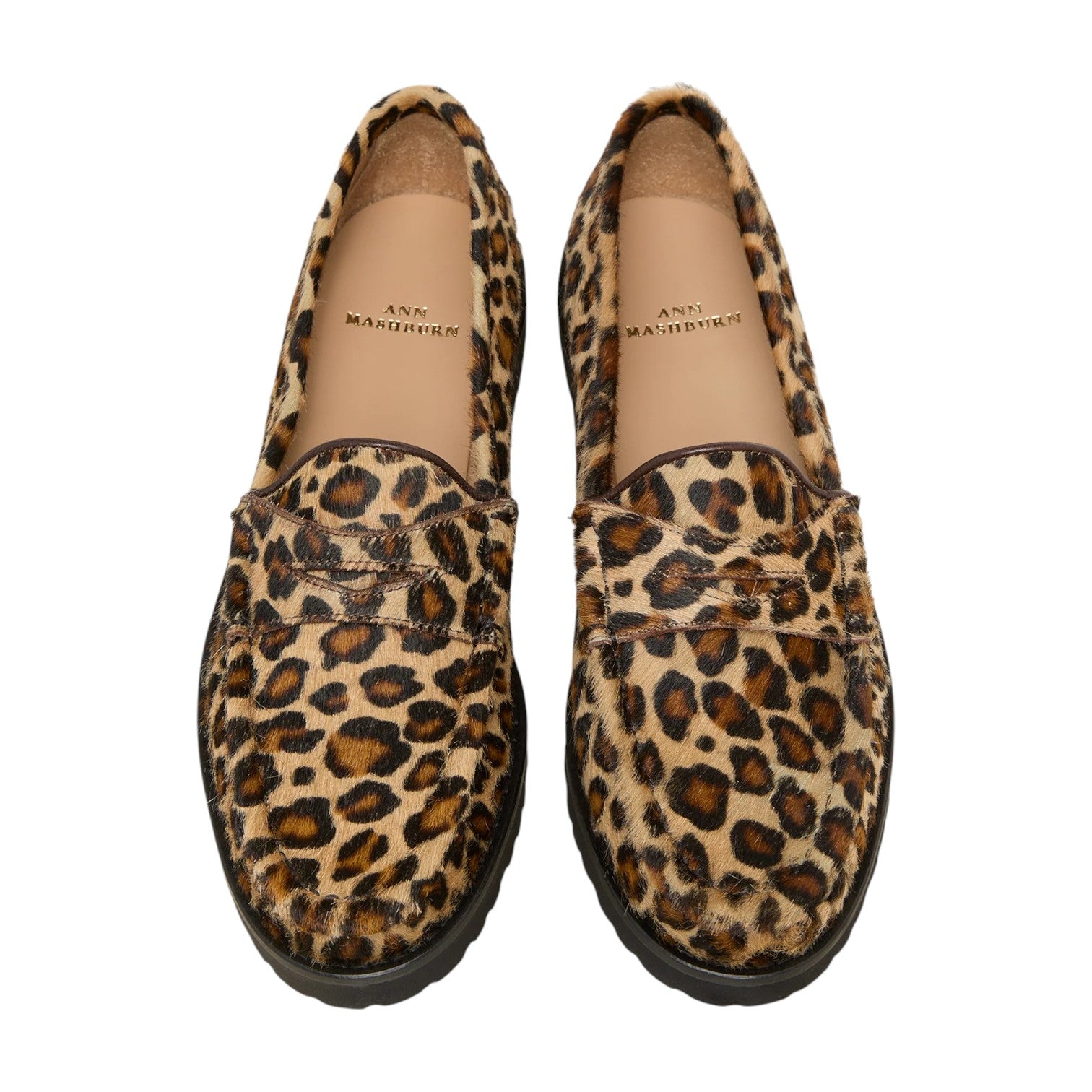 A pair of Ann Mashburn Lug Sole Loafers featuring leopard print uppers, black soles, and tan insoles branded with the Ann Mashburn name.