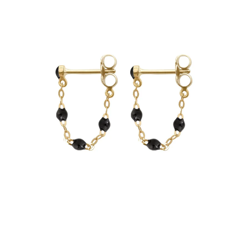 Explore the Gigi Clozeau Classic Gigi Earrings, featuring gold round studs with short chains and black beads. This piece perfectly blends classic elegance with modern flair.