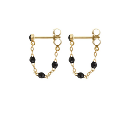 Explore the Gigi Clozeau Classic Gigi Earrings, featuring gold round studs with short chains and black beads. This piece perfectly blends classic elegance with modern flair.