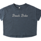 The Rylee & Cru Baby Girls' and Girls' Boxy Tee is a navy blue, short-sleeve crop top with "Beach Babe" embroidered in white on the front.