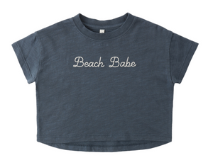 The Rylee & Cru Baby Girls' and Girls' Boxy Tee is a navy blue, short-sleeve crop top with "Beach Babe" embroidered in white on the front.