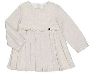The Kidiwi Girls' Ashley Organic Cotton Twill Dress is a cream long-sleeve style for young children, featuring a pleated skirt, scalloped bodice detail, and a decorative button.