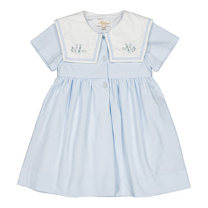 The Kidiwi Baby Girls' and Girls' Paola Dress features sky blue piqué fabric, short sleeves, a white sailor collar with light blue floral embroidery, and front buttons.