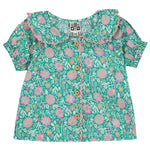 The Baby Girls' Aria Shirt by Bonton is a short-sleeve green blouse with a pink and beige floral pattern, ruffled collar, wooden front buttons, and is made from 100% cotton.