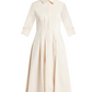 The Signature Jazz Dress by Simkhai is a cream-colored, long-sleeved, collared midi dress with a front button-down design and a fitted waist. Made from cotton poplin, it showcases an elegant A-line silhouette, ideal for any occasion.