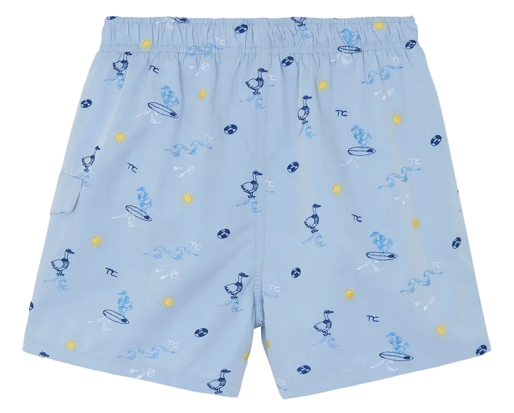 Discover the Boys’ Printed Swim Short by Tartine et Chocolat—light blue swim shorts featuring an elastic waistband and a fun print of ducks on surfboards, suns, and waves in blue and yellow. Perfect for adventurous young explorers ready to make a splash on their next beach trip!.