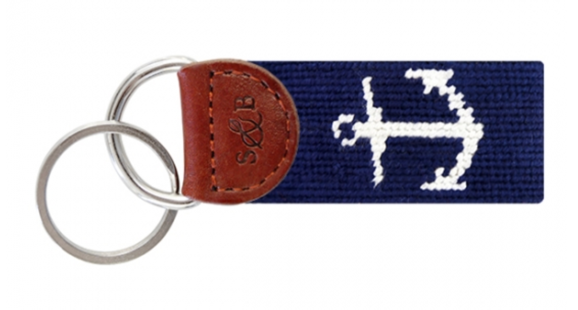 The Anchor Key Fob by Smathers & Branson includes a navy needlepoint strap with a white anchor design, two metal rings, and an elegant Italian leather patch.