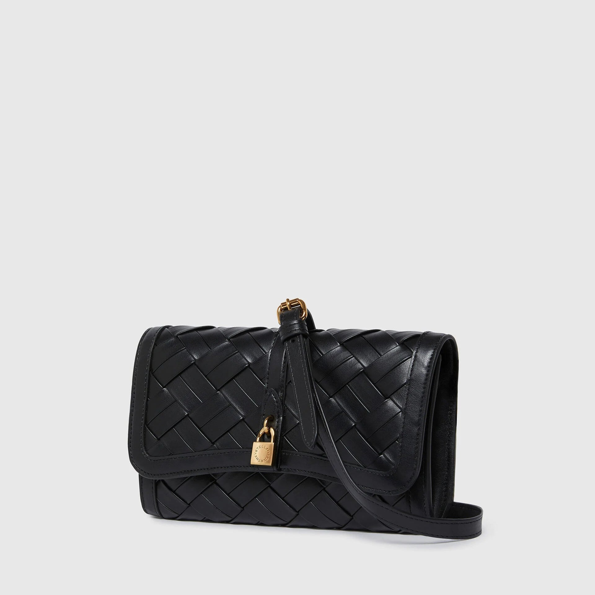 The Stella McCartney Stella Woven Ryder Wallet with Strap features black woven leather, a flap closure, gold padlock detail, and an adjustable strap, elegantly displayed against a plain light background.