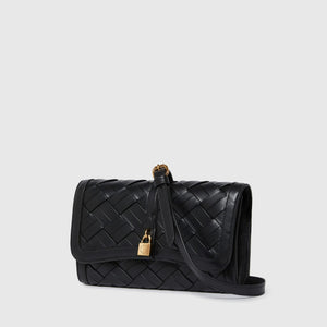 The Stella McCartney Stella Woven Ryder Wallet with Strap features black woven leather, a flap closure, gold padlock detail, and an adjustable strap, elegantly displayed against a plain light background.