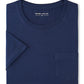 A folded navy blue Crown Comfort Short-Sleeve Pocket Tee by Peter Millar is displayed, crafted from soft midweight organic cotton with a chest pocket and a visible "Peter Millar" label inside the collar. This tee combines everyday comfort and style.