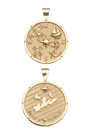 The Jane Win Destination Pendant Necklace Collection features two gold necklaces: one with a compass rose, sailboat, anchor, and more; the other engraved with a map, coordinates, and a star.