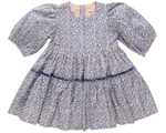 The Girls' Maribelle Dress by Pink Chicken features soft cotton poplin with a blue climbing floral print on light pink, puffed sleeves, round neckline, and a gathered tiered skirt.