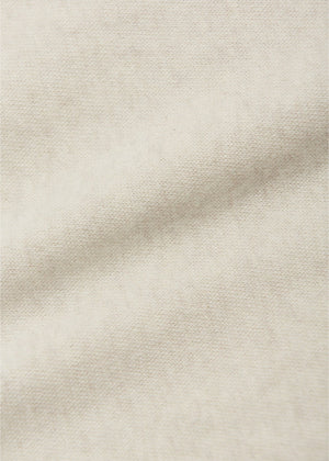 A close-up of the light beige Baby Enes Brushed Knit Leggings by Arsene & Les Pipelettes shows the textured weave and a soft diagonal fold, highlighting their ideal fabric quality for babies.