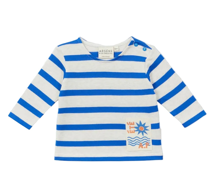 The Arsene & Les Pipelettes Baby Sailor Shirt features long sleeves, classic blue and white horizontal stripes, two blue shoulder buttons, and a small orange and blue summer-themed graphic near the hem. Crafted from soft organic cotton jersey, this gentle baby shirt offers timeless style while being kind to delicate skin.