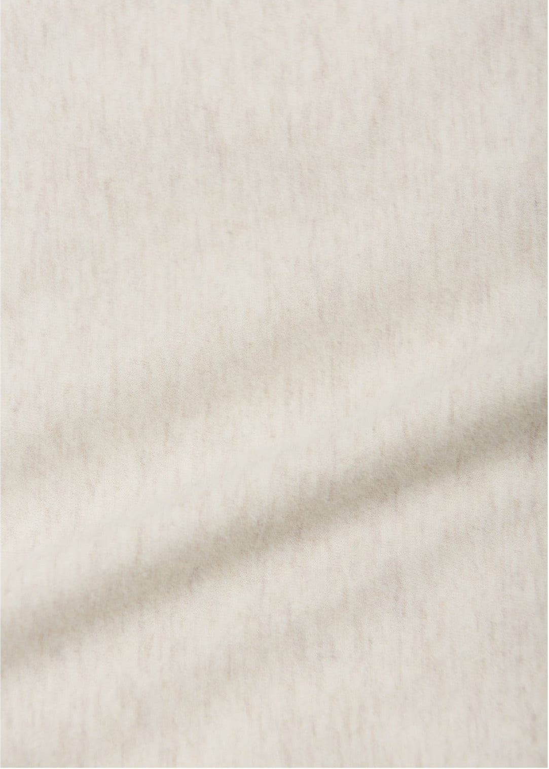 Close-up of the soft, light beige fabric of the Arsene & Les Pipelettes Baby Boys' Gregoire Hockey T-Shirt, featuring a subtle texture and a faint diagonal crease—perfect for your little one.