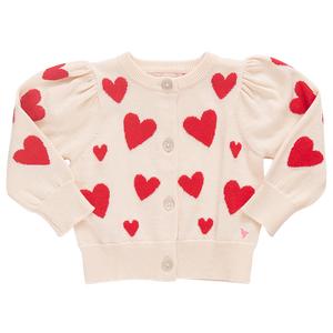 The Pink Chicken Girls' Constance Sweater is a cream cardigan featuring puffed shoulders, sleeves with red heart patterns, and a glitter button front for added sparkle.