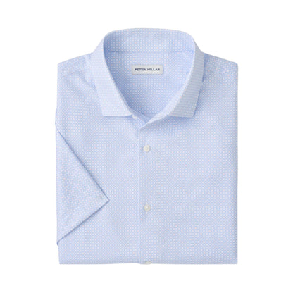 The Peter Millar Baldwin Performance Sport Shirt is light blue, short-sleeve, features a subtle geometric pattern, two-way stretch, and has a label inside the collar.
