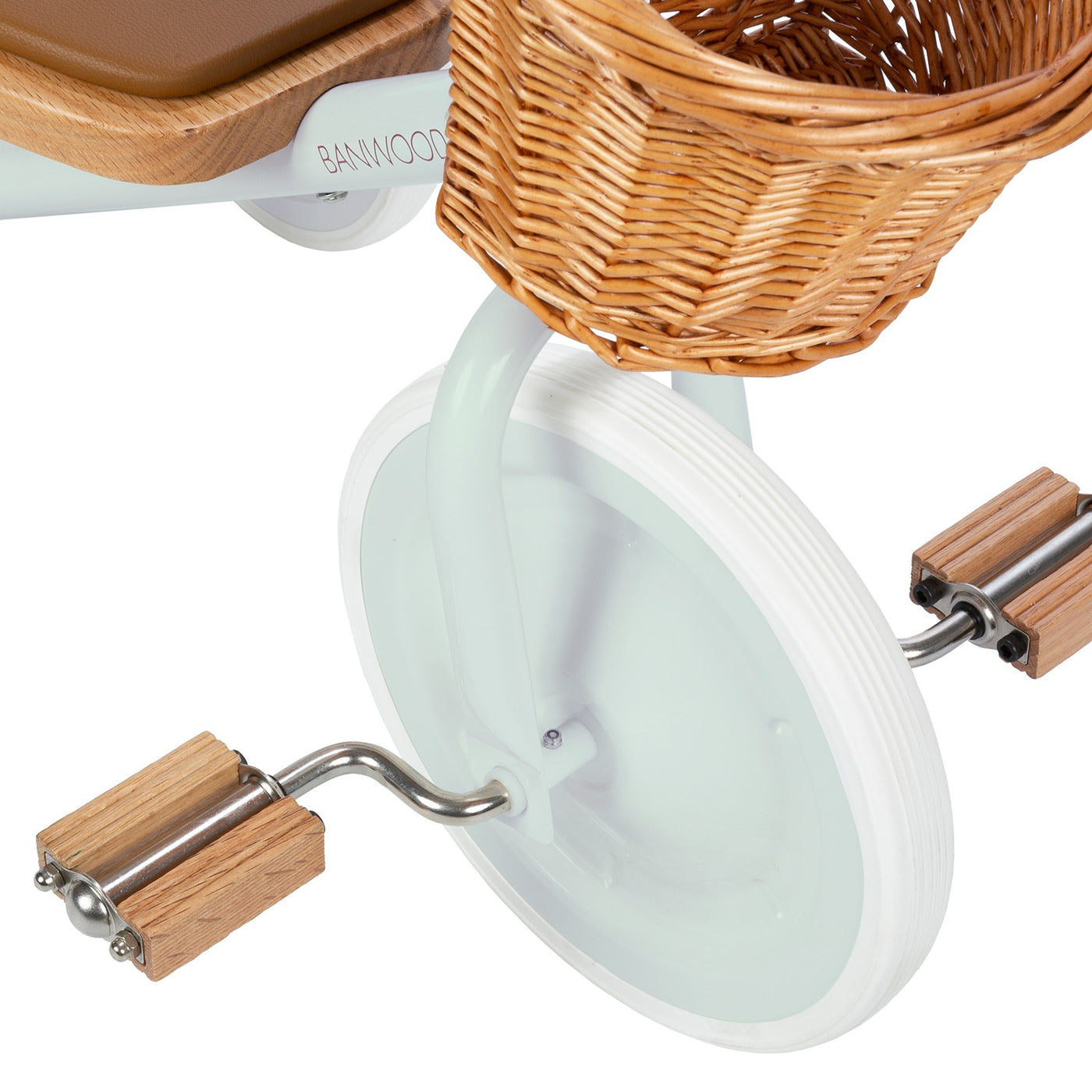 Close-up of the Banwood Kids’ Trike front white wheel, featuring wooden pedals and a charming wicker basket attached above the wheel.