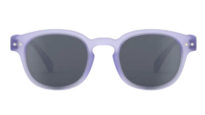 A pair of IZIPIZI Kids’ #C Polarized Sunglasses featuring an ergonomic design, round dark lenses, and a translucent light purple frame, displayed against a white background.