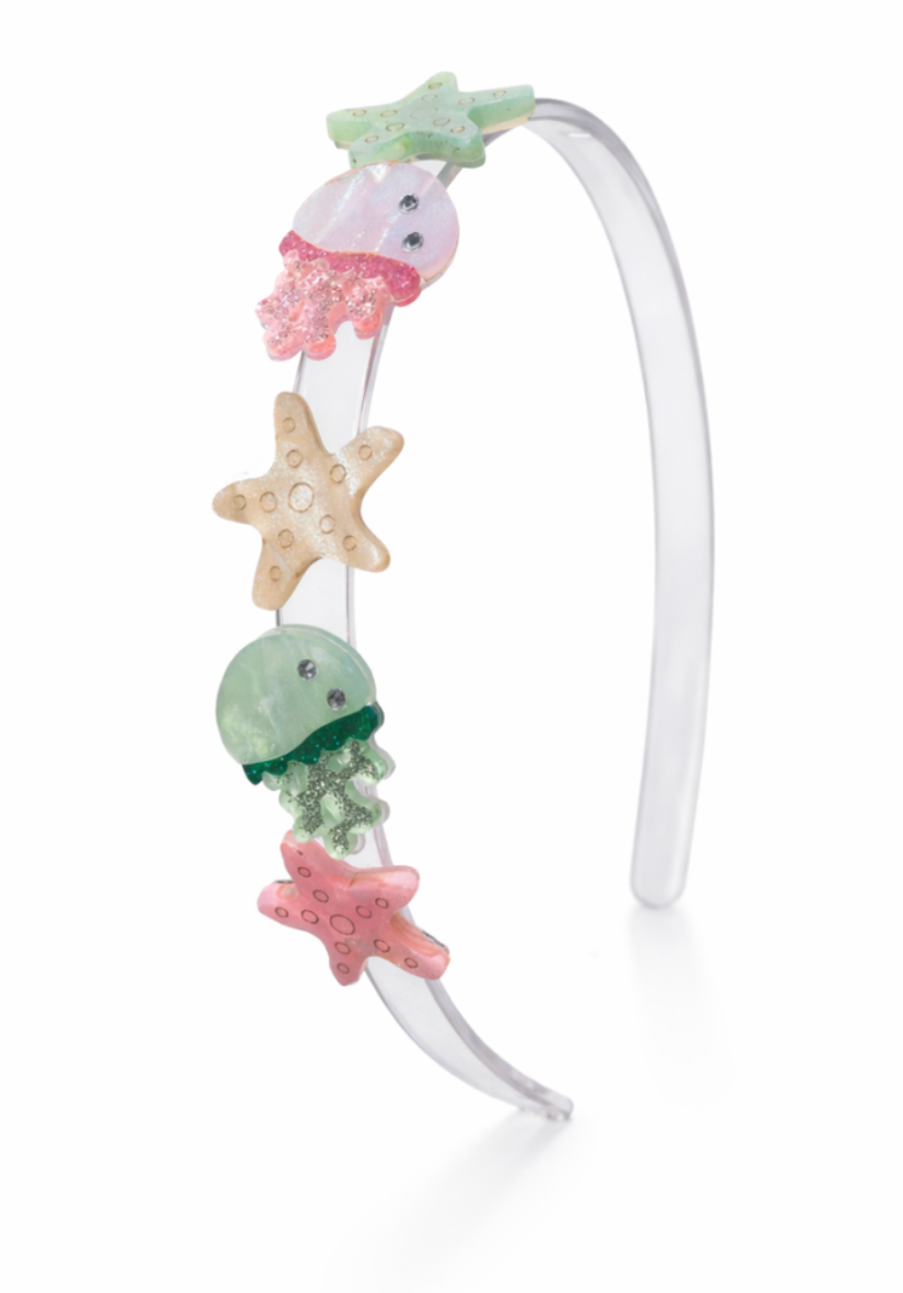 Add playful sparkle to any outfit with the Jellyfish & Stars Headband by Lillies & Roses—a clear headband adorned on one side with colorful, glittery starfish, octopus, and jellyfish decorations for a whimsical summer touch.