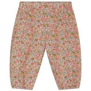 Introducing the Serendipity Baby Light Woven Pants: loose-fitting, baggy baby pants with an elastic waistband and cuffs, showcasing a charming all-over floral pattern in pink, green, and orange tones. Crafted from GOTS certified organic cotton, these pants offer a soft and sustainable choice for your little one.