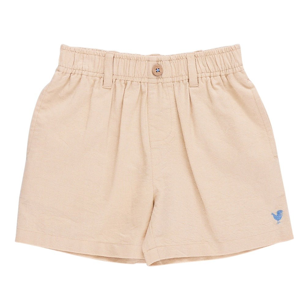 The Boys’ Jackson Short by Pink Chicken features beige cotton canvas, an elastic waistband, button closure, belt loops, and a small blue embroidered logo near the left hem.