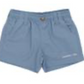 The Boys' Mallard Short by Properly Tied features light blue, moisture-wicking fabric, a button and zip closure, two side pockets, and a small white logo on the lower left leg.