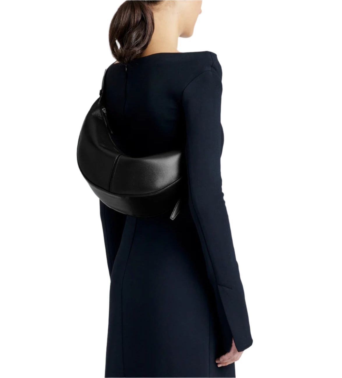 In a sleek, dark long-sleeved dress, the person carries the elegant Proenza Schouler Slide Bag over their shoulder; its supple leather and half-moon shape perfectly complementing the ensemble from behind.