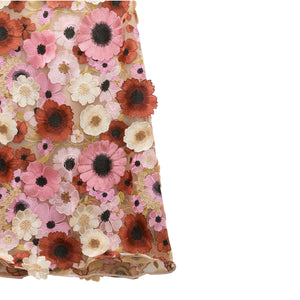 The Blooming Meadow Skirt by Dorothee Schumacher showcases couture 3D floral embroidery in pink, red, white, and beige tones on a sheer fabric.