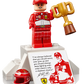 A LEGO® Icons Ferrari F2004 & Michael Schumacher minifigure by Legos - Toyhouse, in a red racing suit, holds a trophy on a podium with a red helmet, quote plaque, and an image of the famous Ferrari F2004 Formula 1 car.