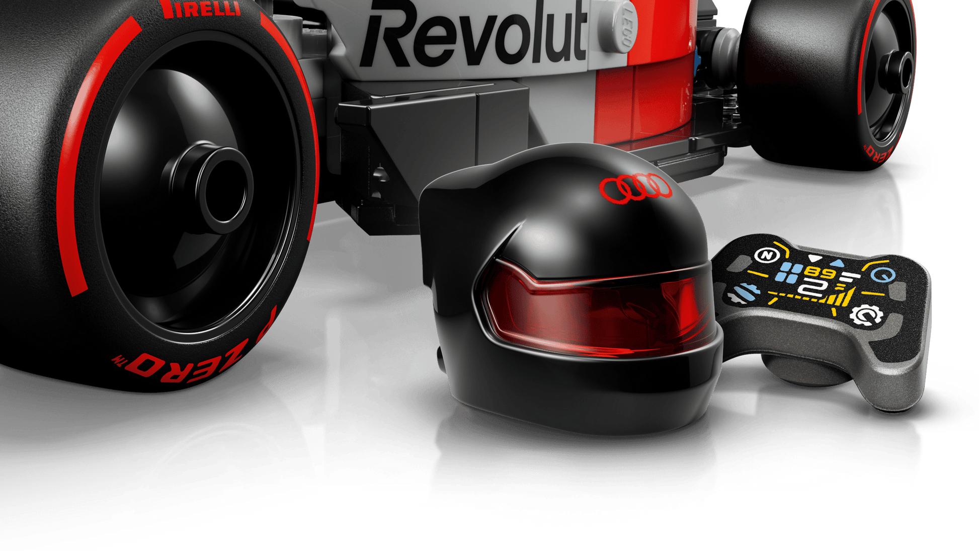 Close-up of the LEGO® Speed Champions Audi Revolut F1® Team R26 Race Car, a black racing helmet with red visor and Audi logo, plus a game controller—ideal for Legos - Toyhouse fans and Formula 1 toy collectors.