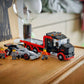 A LEGO® City F1® Display Truck with Audi F1® Race Car by Legos - Toyhouse and three minifigures are arranged on a dresser beside a lamp, photo, and more—ideal for displaying your toy car building kit.