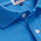 Close-up of the Pensacola Polo Shirt by Love Brand—a blue organic cotton polo with white buttons and a label that features two elephants. A smart-casual essential.