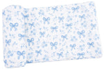 Crafted by Angel Dear, the Swaddle Blanket features white fabric adorned with light blue bows and floral patterns. Folded at one end, this soft blanket is made from lightweight Viscose from Bamboo, offering exceptional comfort for your baby.