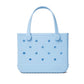 Light blue, rectangular Bitty Bogg® Bag tote from Bogg Bags featuring round cutout holes, sturdy handles, and “bogg” embossed at the bottom right. This compact and washable bag is perfect for everyday use.