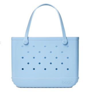 The Original Bogg® Bag by Bogg Bags is a light blue, perforated beach tote featuring two handles. The word “bogg” is embossed on the lower right corner of the front, and its washable design makes it ideal for days spent by the water.