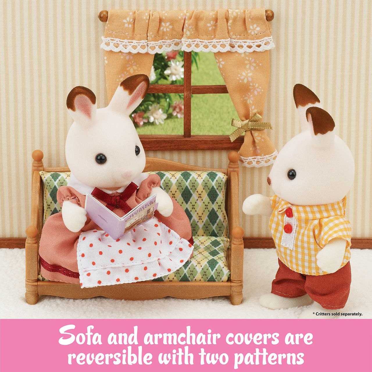Two Calico Critters rabbits are enjoying the Comfy Living Room Set, which features a window, sofa, and curtain. One rabbit sits reading a book while the other stands nearby. The text at the bottom highlights reversible furniture covers to personalize your dollhouse décor.