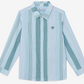 The Boys’ Badge Stripe Shirt by Tartine et Chocolat features light blue and white vertical stripes, long sleeves, a classic collar, and a small embroidered logo on the left chest. Made from soft cotton, this button-up is perfect for casual looks.