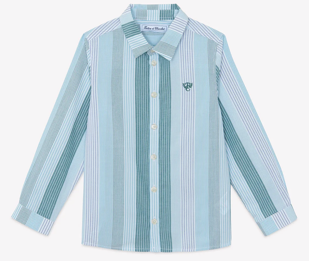 The Boys’ Badge Stripe Shirt by Tartine et Chocolat features light blue and white vertical stripes, long sleeves, a classic collar, and a small embroidered logo on the left chest. Made from soft cotton, this button-up is perfect for casual looks.
