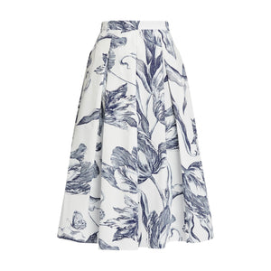 The "Botanical Engraving Pleated Midi Skirt" by Erdem is an ivory cotton poplin A-line skirt adorned with a blue botanical print of large leaves and flowers.