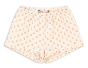 Konges Slojd Baby Girls’ and Girls’ Coco Shorts in light pink muslin, featuring a floral print, ruffled details, pleats, and an elastic waistband, displayed on a white background.